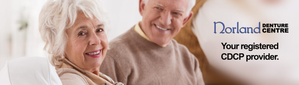 Happy senior couple smiling and sitting on a sofa